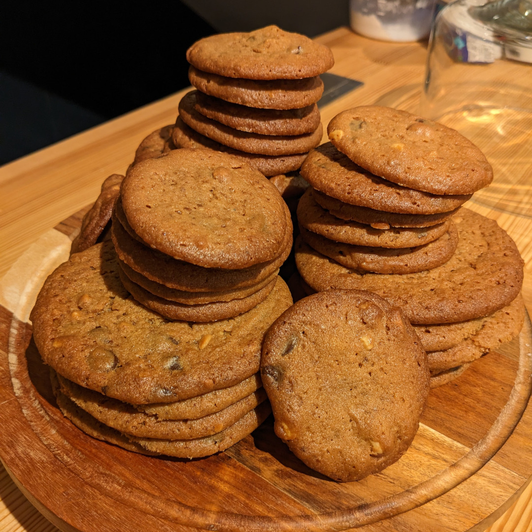 A pile of chocolate chip cookies on a cake plate