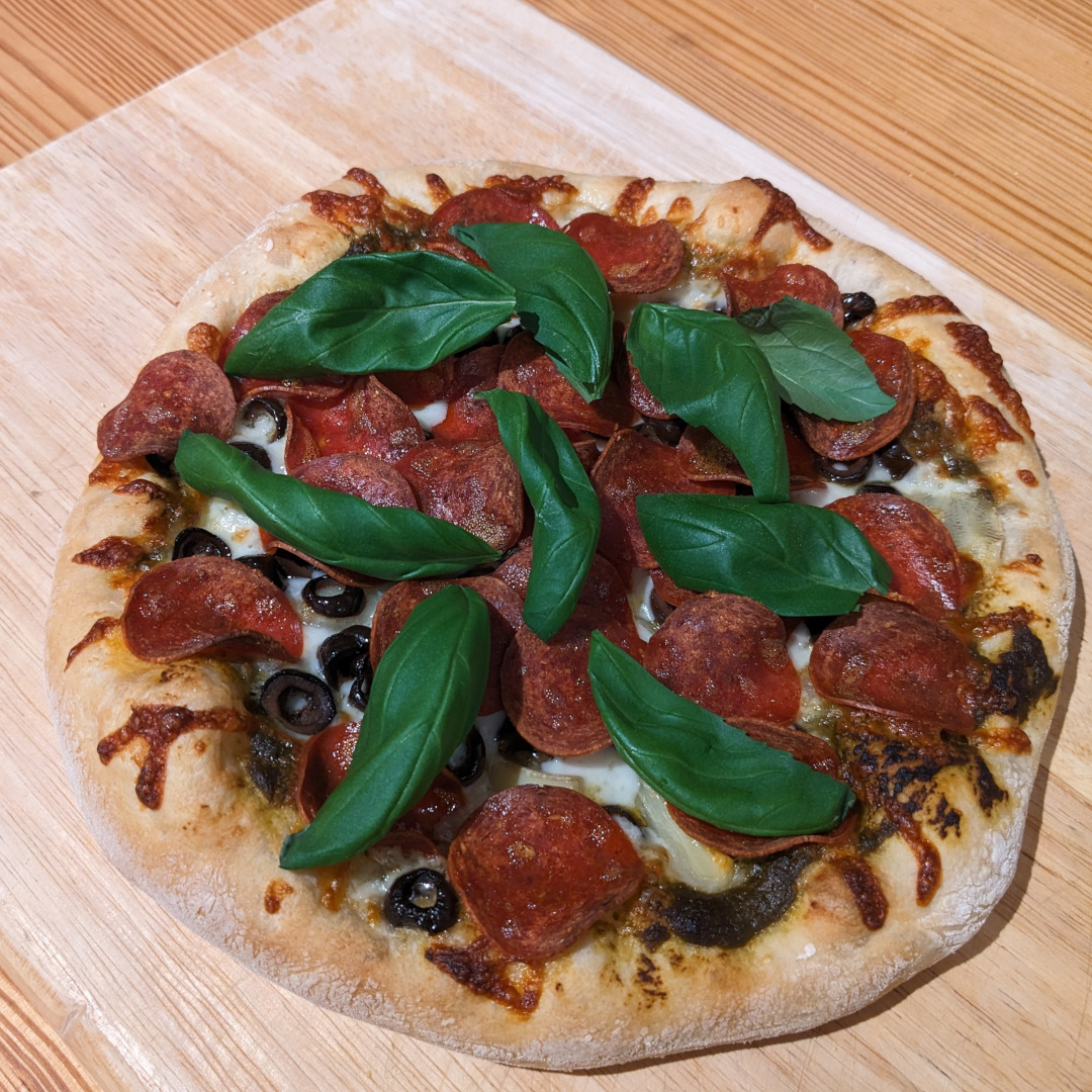 A mini-pizza with turkey pepperoni and fresh basil